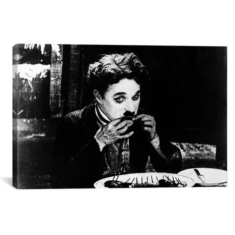 A Film Still Of Charlie Chaplin Eating His Shoe