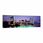 An Illuminated Brooklyn Bridge With Lower Manhattan's Financial District Skyline In The Background, New York City, New York  by Panoramic Images (12"H x 36"W x 1.5"D)